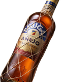 Primer plano de la clásica botella con malla de Ron Brugal Añejo dominicano.