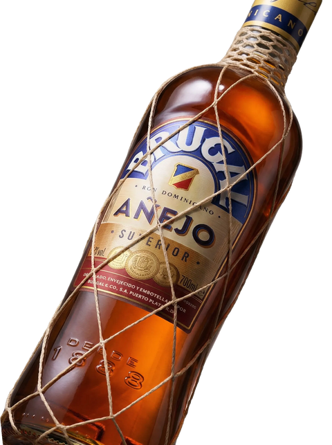 Primer plano de la clásica botella con malla de Ron Brugal Añejo dominicano.