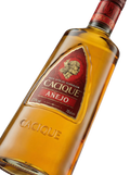 Primer plano de la botella oscura de Ron Cacique Añejo venezolano.