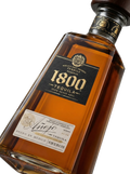 Primer plano de la icónica botella piramidal de Tequila 1800 Añejo.
