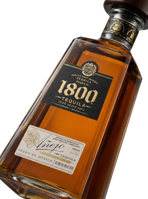 Primer plano de la icónica botella piramidal de Tequila 1800 Añejo.