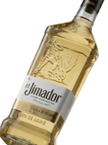 Primer plano de la botella cuadrada clásica de Tequila El Jimador Reposado.